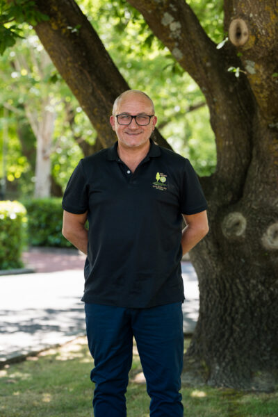 Paul Leeden ARO College Chief operating officer standing infront of a tree in offical ARO College t shirt